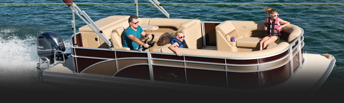 A family riding in a brown and tan pontoon boat across the water